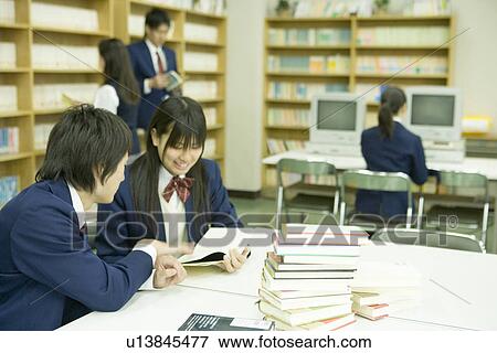 Stock Photo - High school students reading books in library, smiling, blurred motion. Fotosearch
