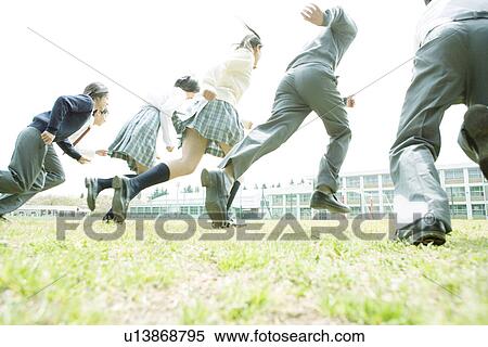 Stock Photography - High school students running on lawn. Fotosearch