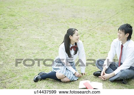Stock Photo - High school students sitting on lawn, smiling. Fotosearch
