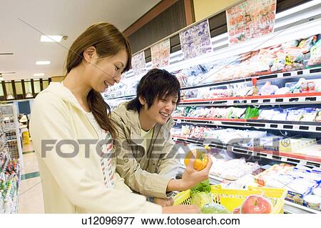 Stock Photo - Couple shopping at supermarket. Fotosearch