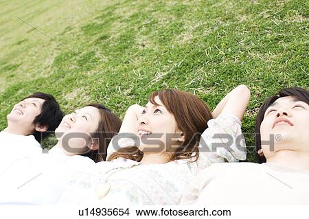 Group of young people lying on grass View Large Photo Image Picture - Group of young people lying on grass. Fotosearch