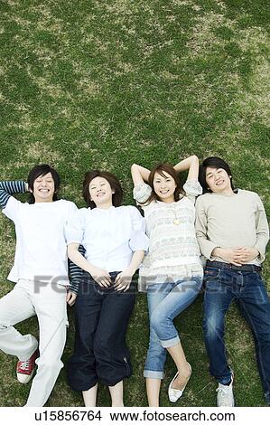Group of young people lying on grass View Large Photo Image Picture - Group of young people lying on grass. Fotosearch