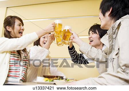 Stock Image - Group of young people toasting beer. Fotosearch