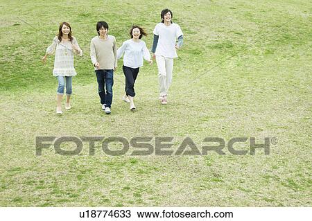 Group of young people walking on grass View Large Photo Image Stock Image - Group of young people walking on grass. Fotosearch