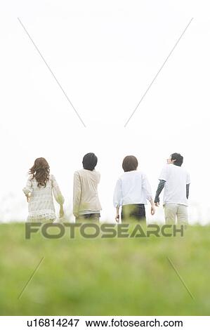 Group of young people walking on grass View Large Photo Image Stock Photo - Group of young people walking on grass. Fotosearch
