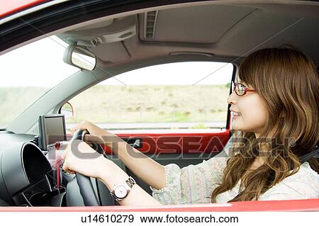 Stock Photo - Profile of young woman driving a car. Fotosearch