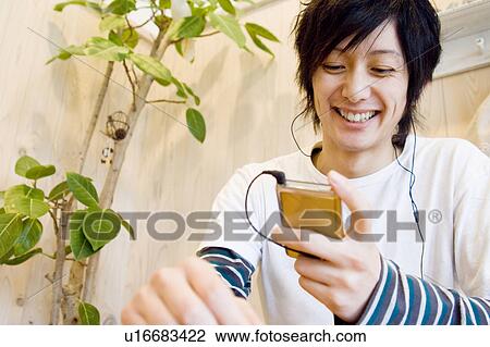 Stock Image - Young man listening to music. Fotosearch