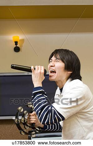 Young man singing karaoke View Large Photo Image Stock Image - Young man singing karaoke. Fotosearch