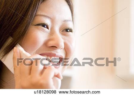 Stock Photo - Young woman on cell phone. Fotosearch