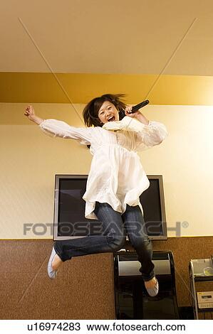 Young woman singing karaoke View Large Photo Image Stock Image - Young woman singing karaoke. Fotosearch