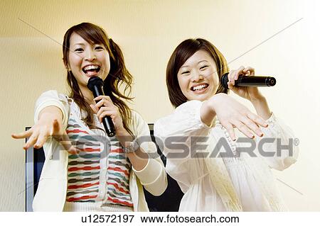 Young women singing karaoke View Large Photo Image Stock Photo - Young women singing karaoke. Fotosearch
