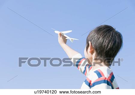 Stock Image - A Boy Holding Paper Airplane. Fotosearch