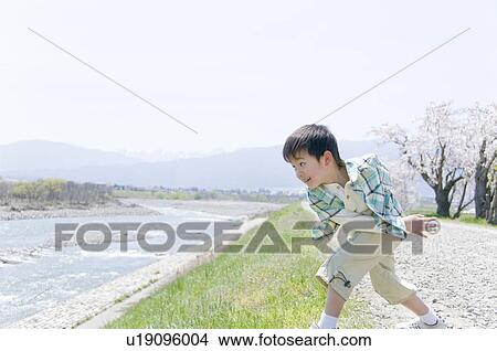 A Boy Throwing Stones to River View Large Photo Image Picture - A Boy Throwing Stones to River. Fotosearch