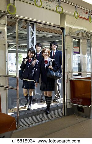 Picture - High school students boarding train at station, smiling. Fotosearch