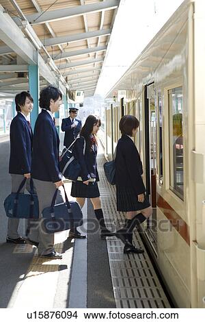 Picture - High school students boarding train at station. Fotosearch