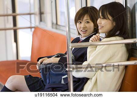 Picture - High school students on the train, sitting on the seat, smiling. Fotosearch