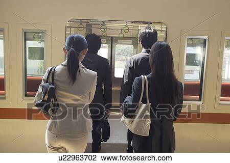 Stock Image - People boarding train at station. Fotosearch