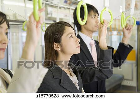 Stock Photo - People hanging on to straps. Fotosearch