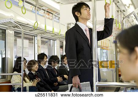 People on the train, businessman hanging on to strap View Large Photo Image Stock Image - People on the train, businessman hanging on to strap. Fotosearch