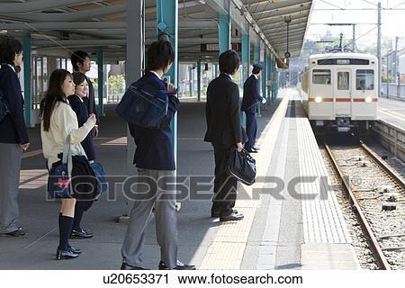 Stock Image - People waiting for the train at platform. Fotosearch