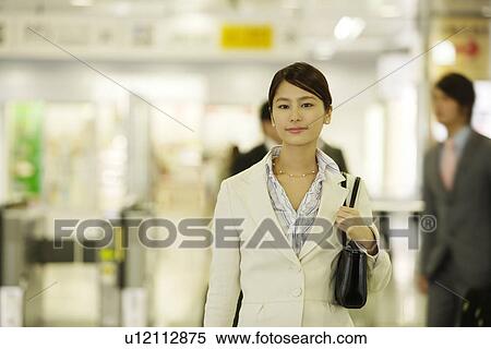Stock Photography - Portrait of a young woman standing in the station, differential focus. Fotosearch