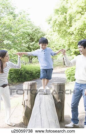 Stock Photo - Son and Two Parent Playing in Park. Fotosearch