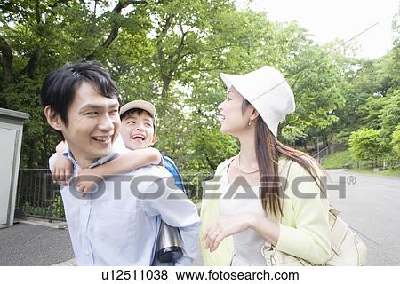 Stock Photo - Two Parents and Son, Son Piggybacks on Father. Fotosearch