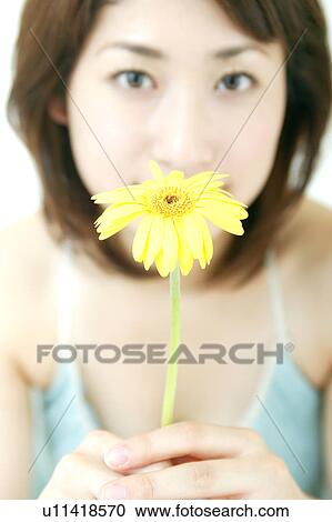 Stock Image - A young woman kissing to a flower. Fotosearch