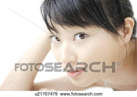 Stock Photo - A young woman looking at camera. Fotosearch