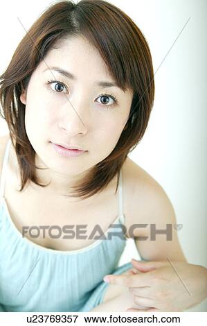 Stock Photo - A young woman looking at camera. Fotosearch