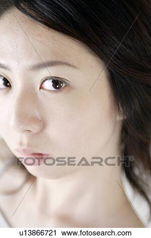 Stock Image - A young woman looking down. Fotosearch