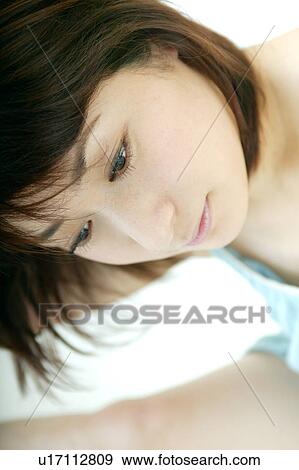 Stock Photo - A young woman looking down. Fotosearch