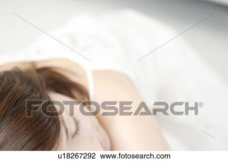 Stock Image - A young woman lying down. Fotosearch