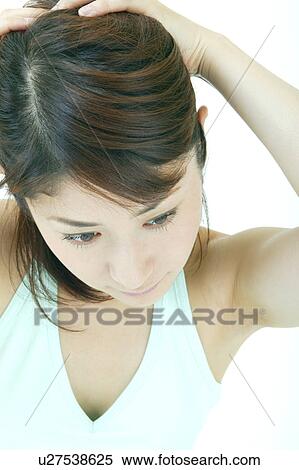 Stock Photography - A young woman preparing her hair. Fotosearch