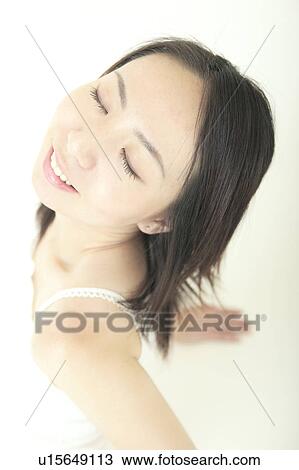 Stock Image - A young woman smiling with her eyes closed. Fotosearch