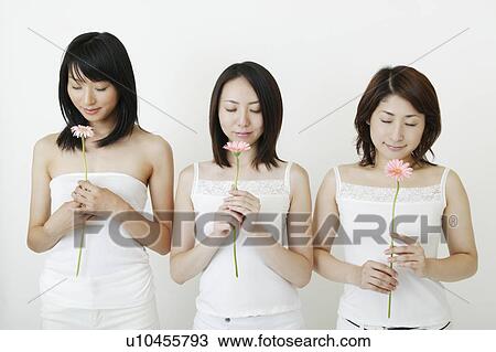 Three women holding flowers View Large Photo Image Stock Image - Three women holding flowers. Fotosearch
