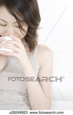 Stock Image - A young woman drinking. Fotosearch