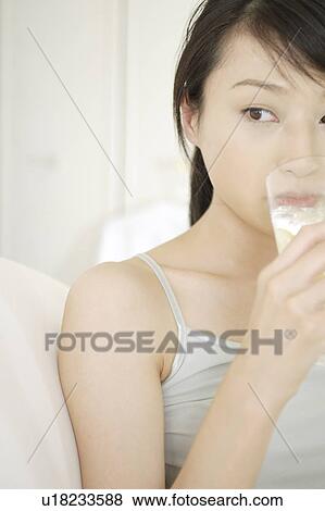 Stock Photo - A young woman drinking. Fotosearch