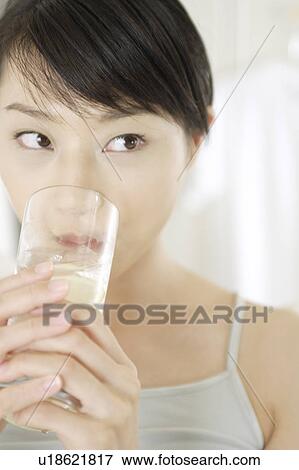 Stock Photo - A young woman drinking. Fotosearch