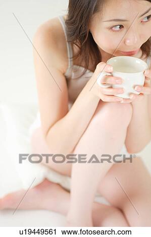 A young woman holding a cup View Large Photo Image Stock Image - A young woman holding a cup. Fotosearch