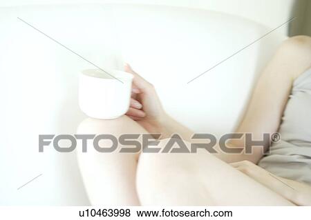 A young woman holding a cup View Large Photo Image Stock Photo - A young woman holding a cup. Fotosearch