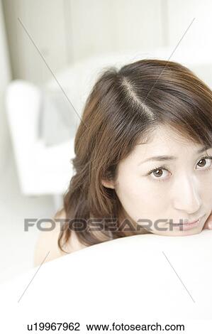 Stock Image - A young woman looking at a camera. Fotosearch