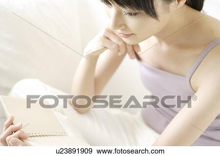 Stock Photo - A young woman looking at a memo. Fotosearch
