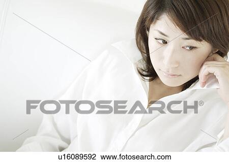 Stock Image - A young woman looking down. Fotosearch