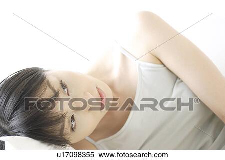 A young woman lying down View Large Photo Image Stock Photography - A young woman lying down. Fotosearch