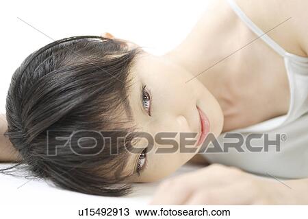 Stock Image - A young woman lying. Fotosearch