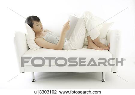 Stock Image - A young woman reading a book. Fotosearch
