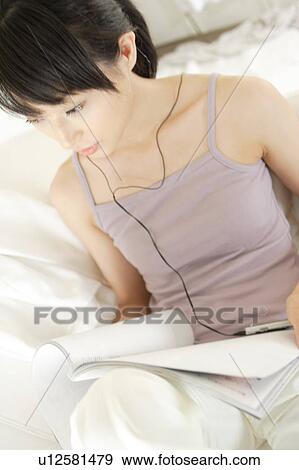 Stock Photo - A young woman reading a magazine. Fotosearch