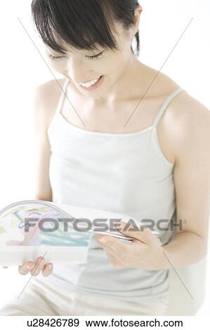 Stock Photo - A young woman reading a magazine. Fotosearch