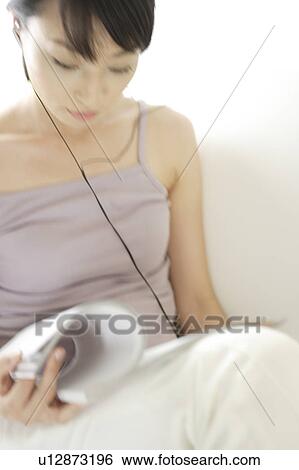 Stock Photograph - A young woman reading a magazine. Fotosearch